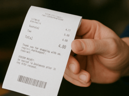 Close up of a person holding a thermal receipt at a restaurant in Hanford California highlighting concerns over BPA exposure and cancer risks linked to receipt paper