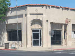 Interior of the condemned building at 103 North Dowdy Street in downtown Hanford California showing severe structural damage exposed framing debris and signs of neglect highlighting public s